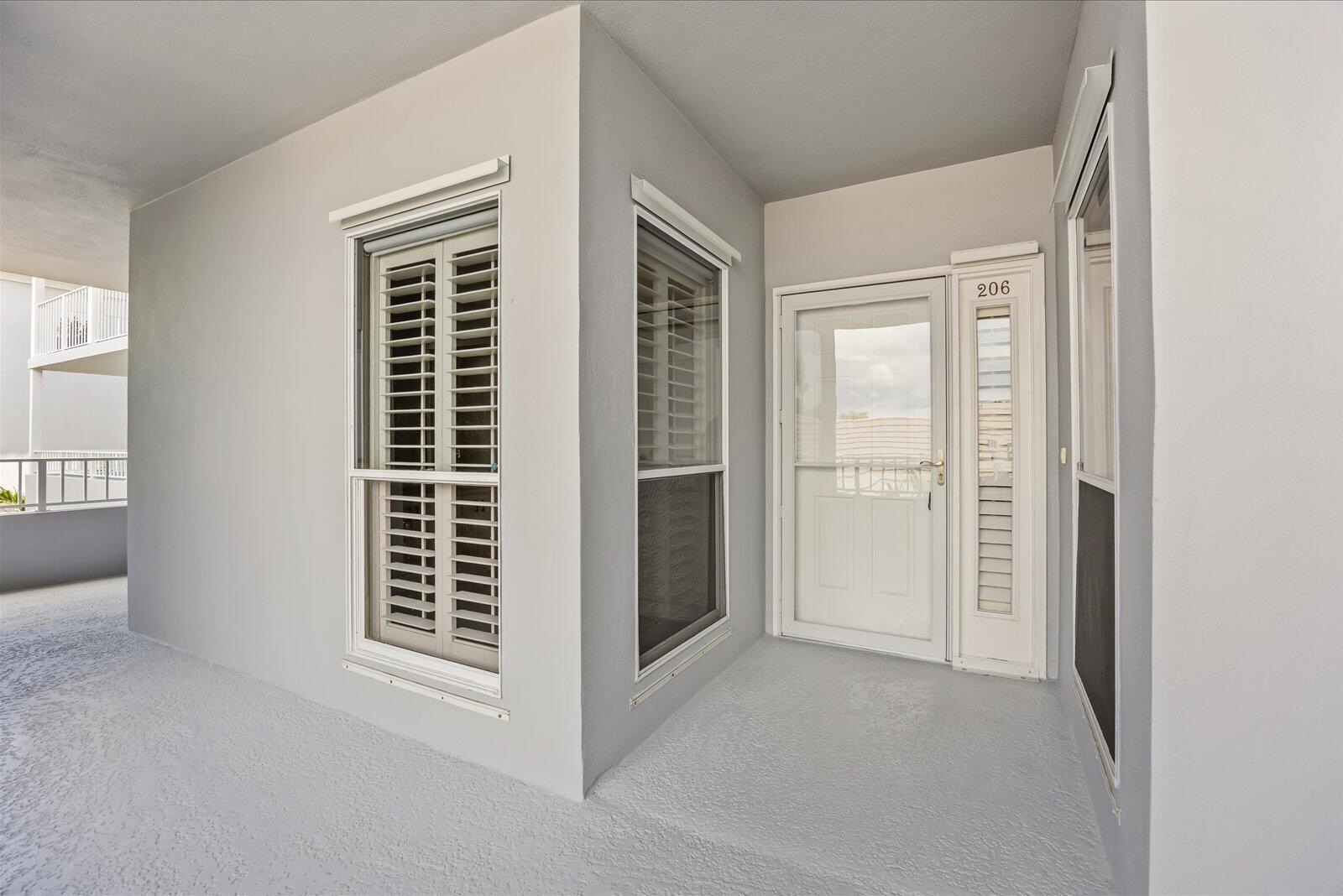 A covered entryway features a white door labeled 206, two windows, and light gray walls — 1903 Bay Road # 206, Vero Beach FL 32963, VERO BEACH, FL