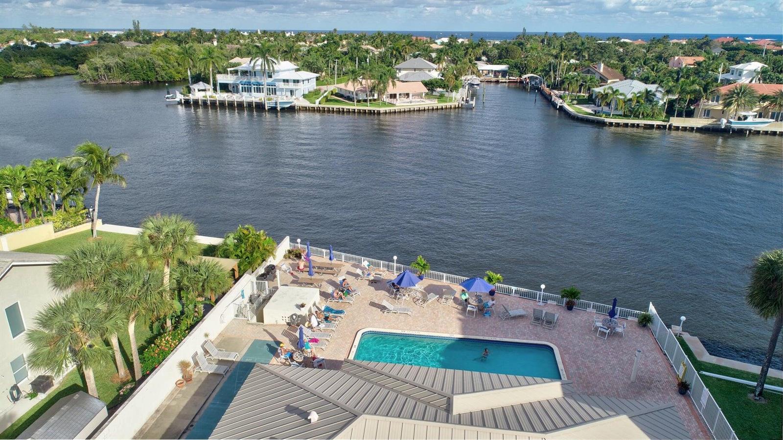 A swimming pool with a five-foot depth marker sits in front of a waterfront patio — 650 Snug Harbor Drive # G310, Boynton Beach FL 33435, BOYNTON BEACH, FL