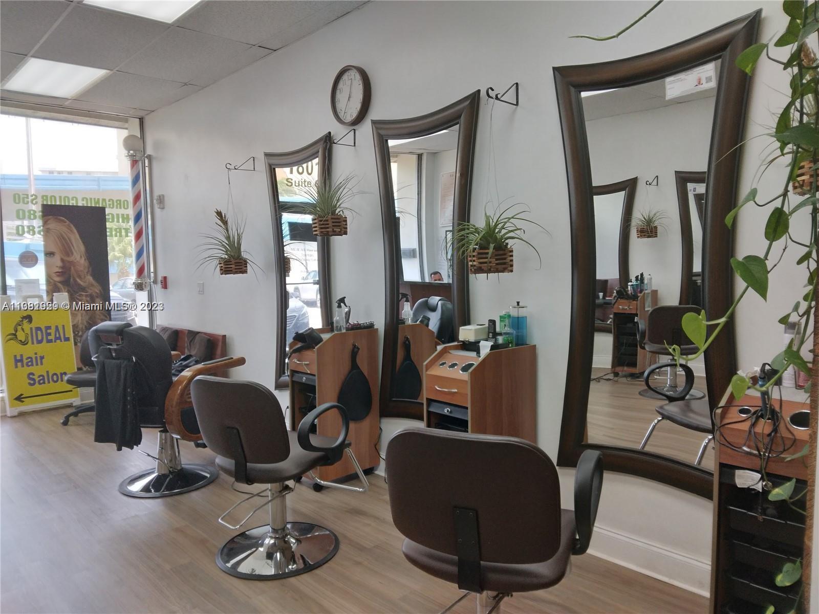A hair salon interior features three styling stations with mirrors, chairs, and hanging plants — 1801 S Ocean Dr, Hallandale Beach FL 33009, HALLANDALE BEACH, FL