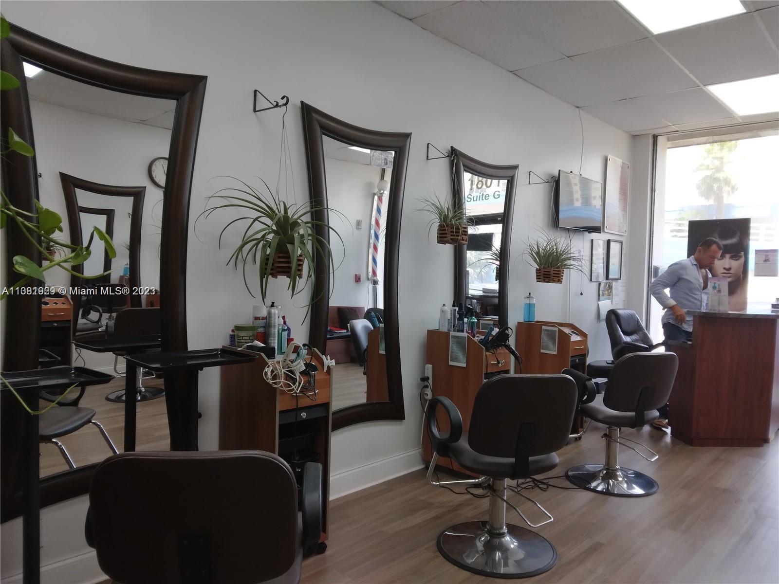A hair salon interior features three styling stations with mirrors, chairs, and hanging plants — 1801 S Ocean Dr, Hallandale Beach FL 33009, HALLANDALE BEACH, FL