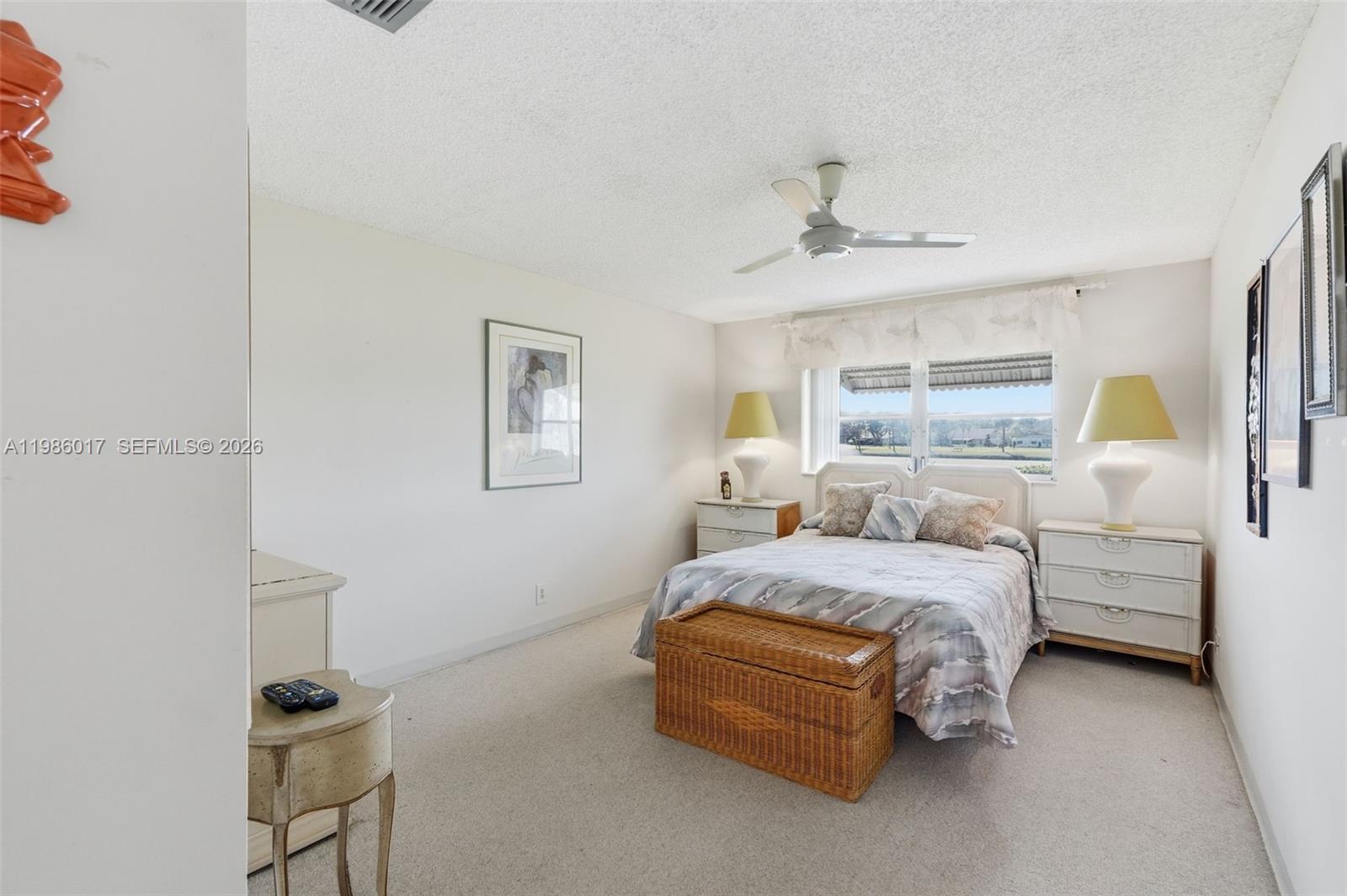 A bedroom features a bed, two nightstands, a wicker trunk, and a window with blinds — 3471 Christopher St, West Palm Beach FL 33417, WEST PALM BEACH, FL