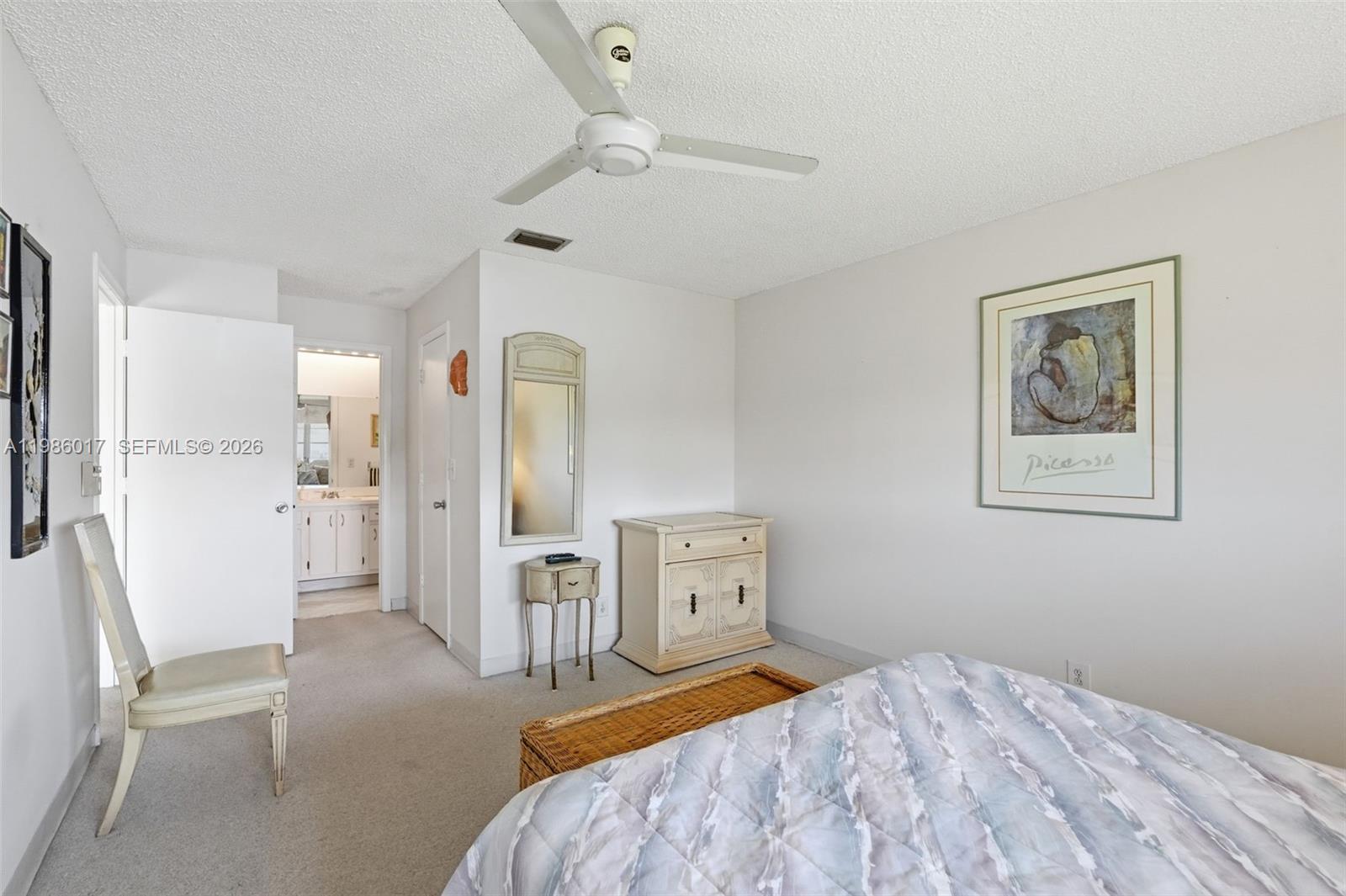 A bedroom features a ceiling fan, a small dresser, a mirror, and a framed print — 3471 Christopher St, West Palm Beach FL 33417, WEST PALM BEACH, FL