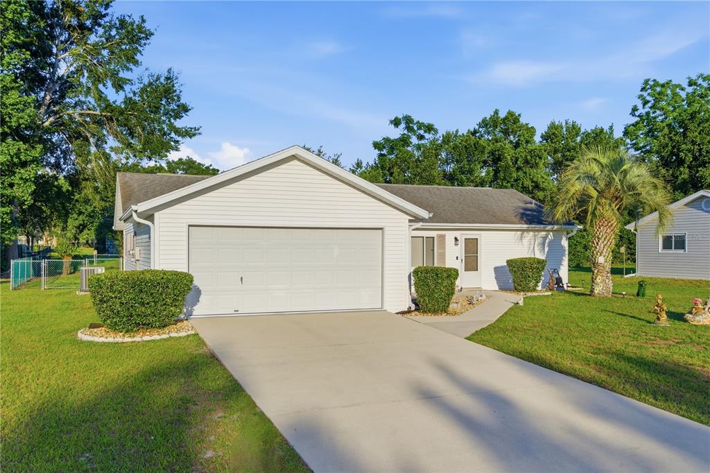 A white, single-story house with a two-car garage, a concrete driveway, and a front lawn — 11241 SW 77TH COURT, OCALA, FL