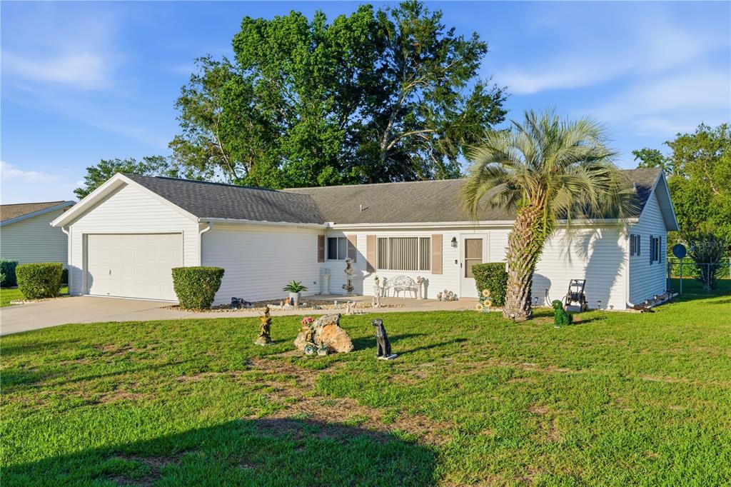 A white, single-story ranch-style house with a two-car garage and a front lawn — 11241 SW 77TH COURT, OCALA, FL