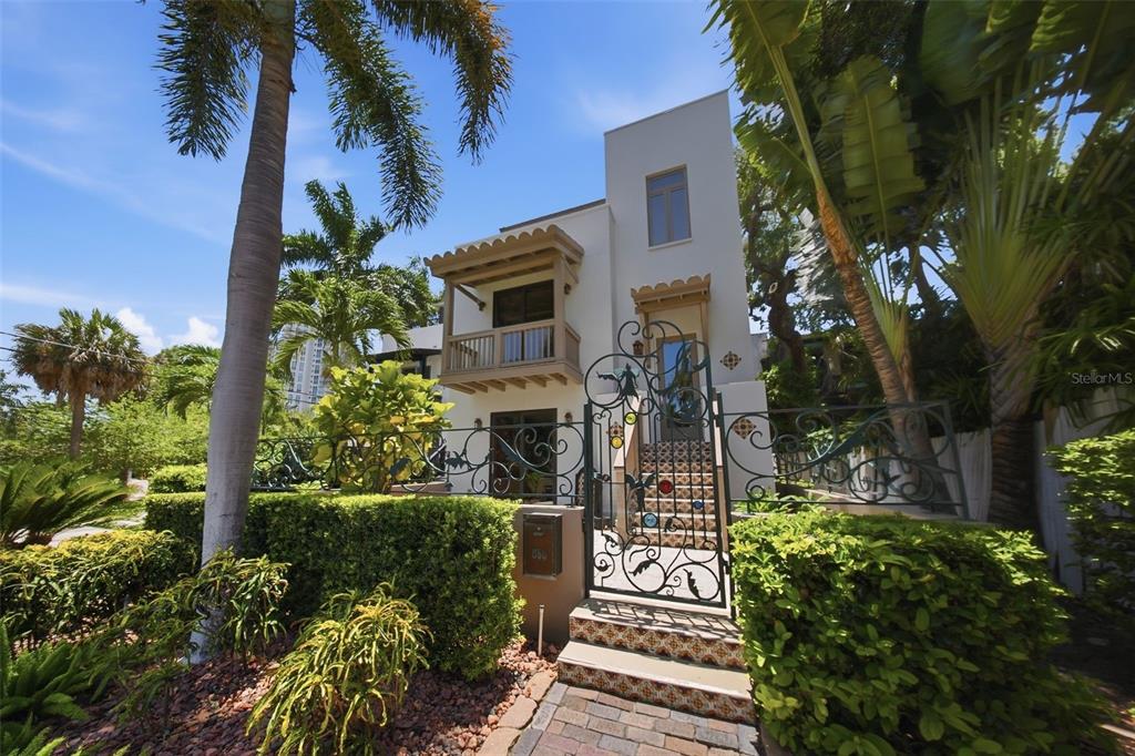 A two-story white stucco house features a decorative wrought iron gate and a tiled staircase — 650 BEACH DRIVE NE, ST PETERSBURG, FL