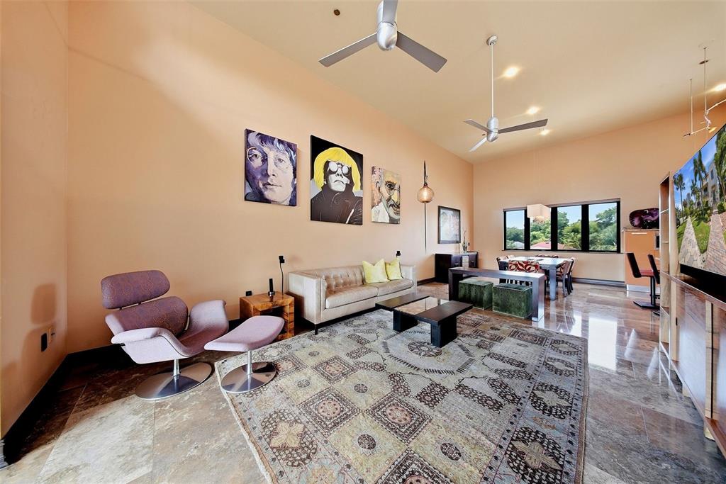 A living room with tile floors, a patterned rug, modern furniture, and wall art — 650 BEACH DRIVE NE, ST PETERSBURG, FL