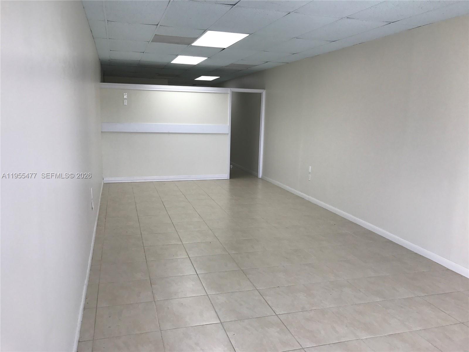 An empty commercial office space features beige walls, tiled flooring, and a drop ceiling — 10509 SW 40th St # 10509, Miami FL 33165, MIAMI, FL