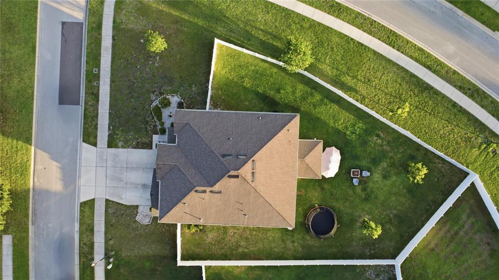 An aerial view shows a house with a fenced backyard, a trampoline, and a driveway — 1419 AVILA AVENUE, DELTONA, FL