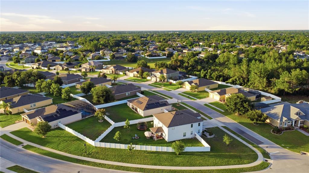 An aerial view of a suburban neighborhood featuring single-family homes with fenced backyards and streets — 1419 AVILA AVENUE, DELTONA, FL