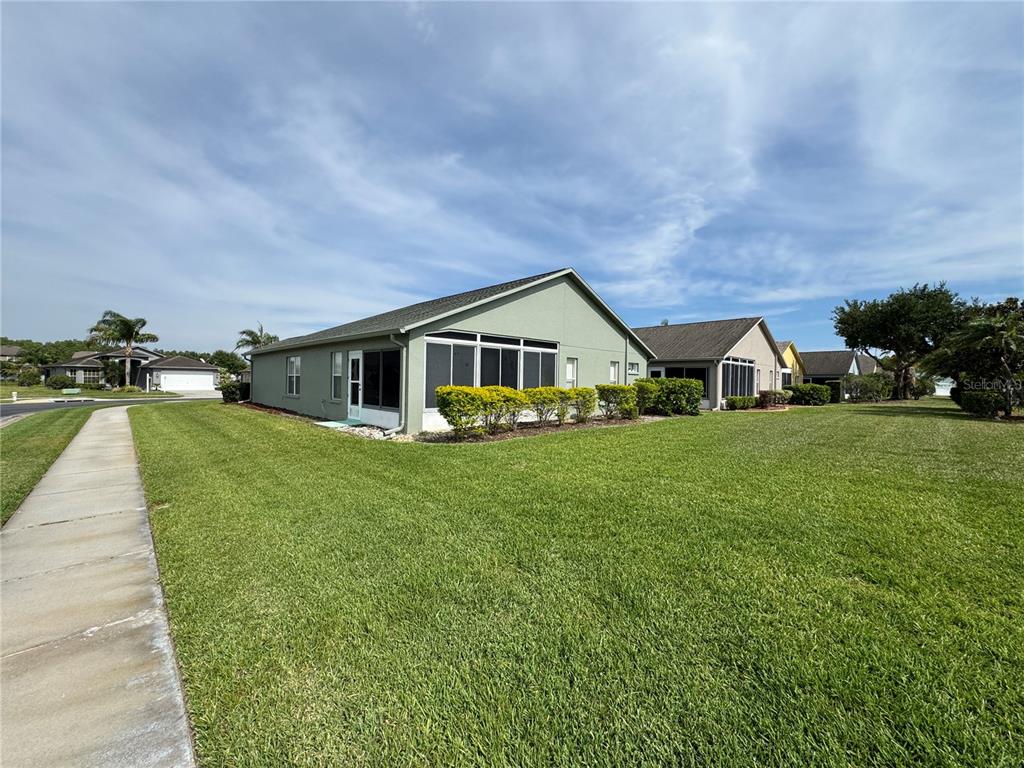 A single-story house with a green exterior, a two-car garage, and a manicured lawn — 1852 ARBOR KNOLL LOOP, TRINITY, FL