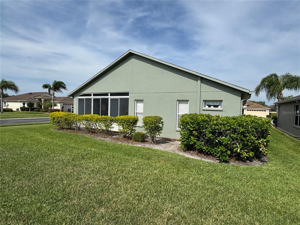 A view of the side and rear exterior of a house with a screened-in porch — 1852 ARBOR KNOLL LOOP, TRINITY, FL