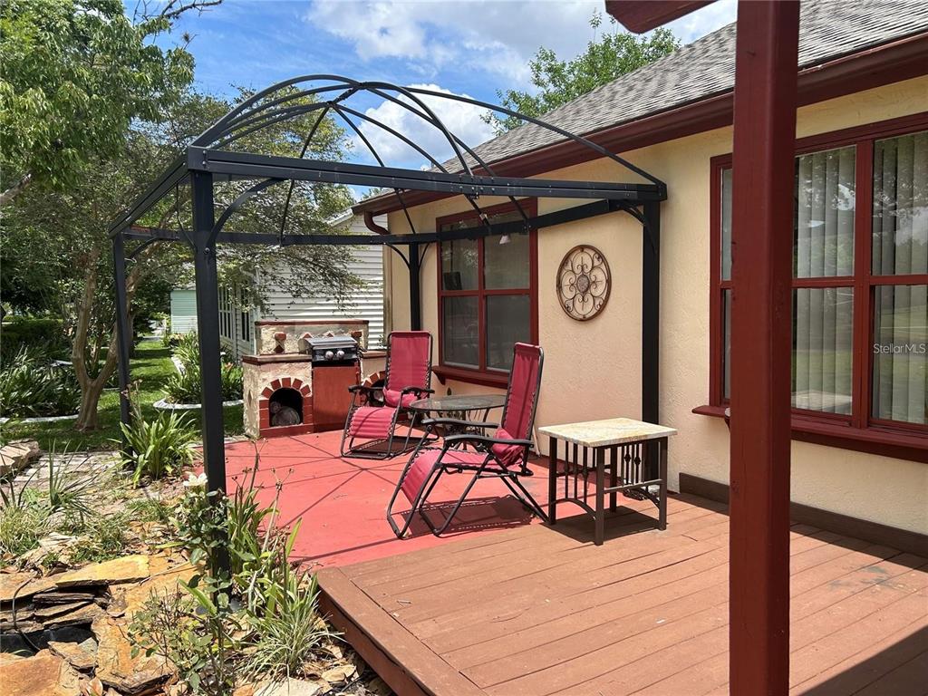 A patio features a metal gazebo, a built-in grill, and outdoor furniture on a deck — 867 CORTEZ AVENUE, THE VILLAGES, FL