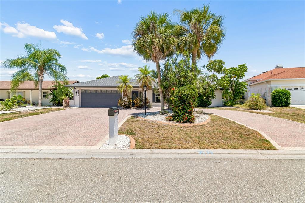 A single-story house with a paved driveway, palm trees, and a two-car garage — 6331 COCOA LANE, APOLLO BEACH, FL