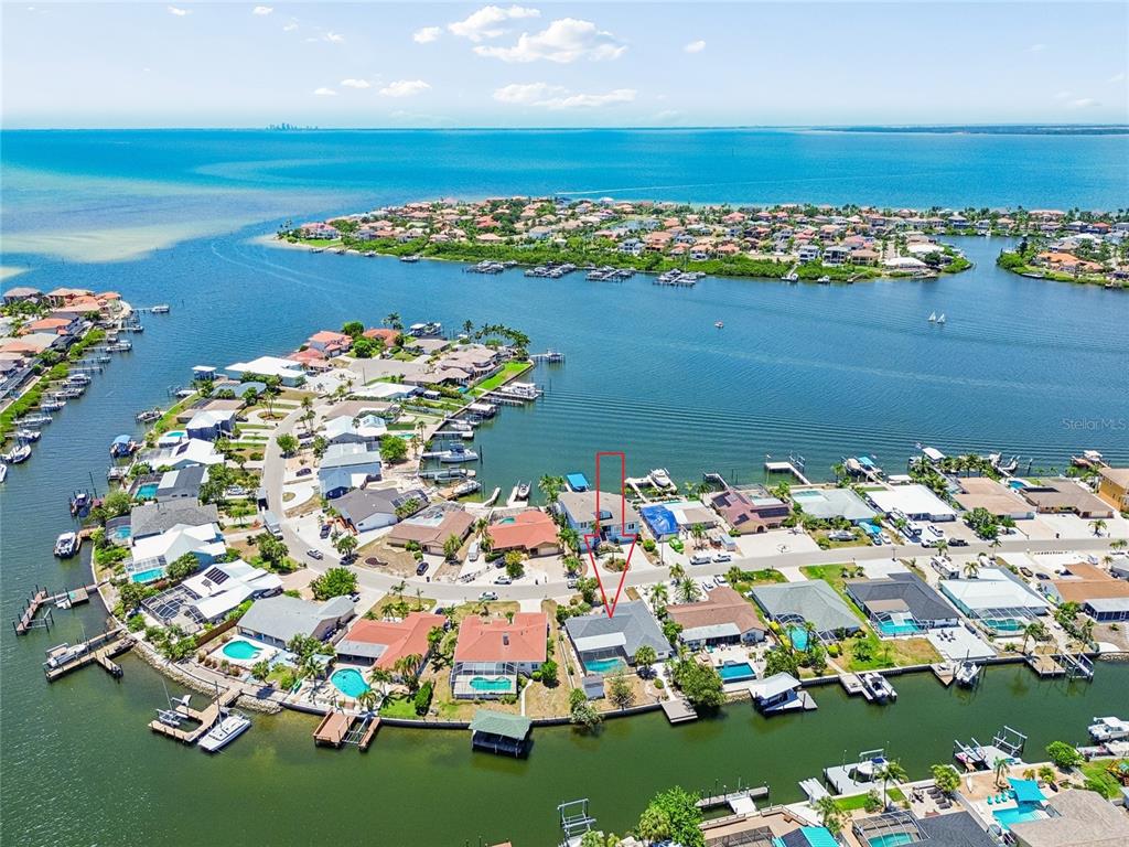 An aerial view shows a waterfront residential neighborhood with a red arrow pointing to a house — 6331 COCOA LANE, APOLLO BEACH, FL