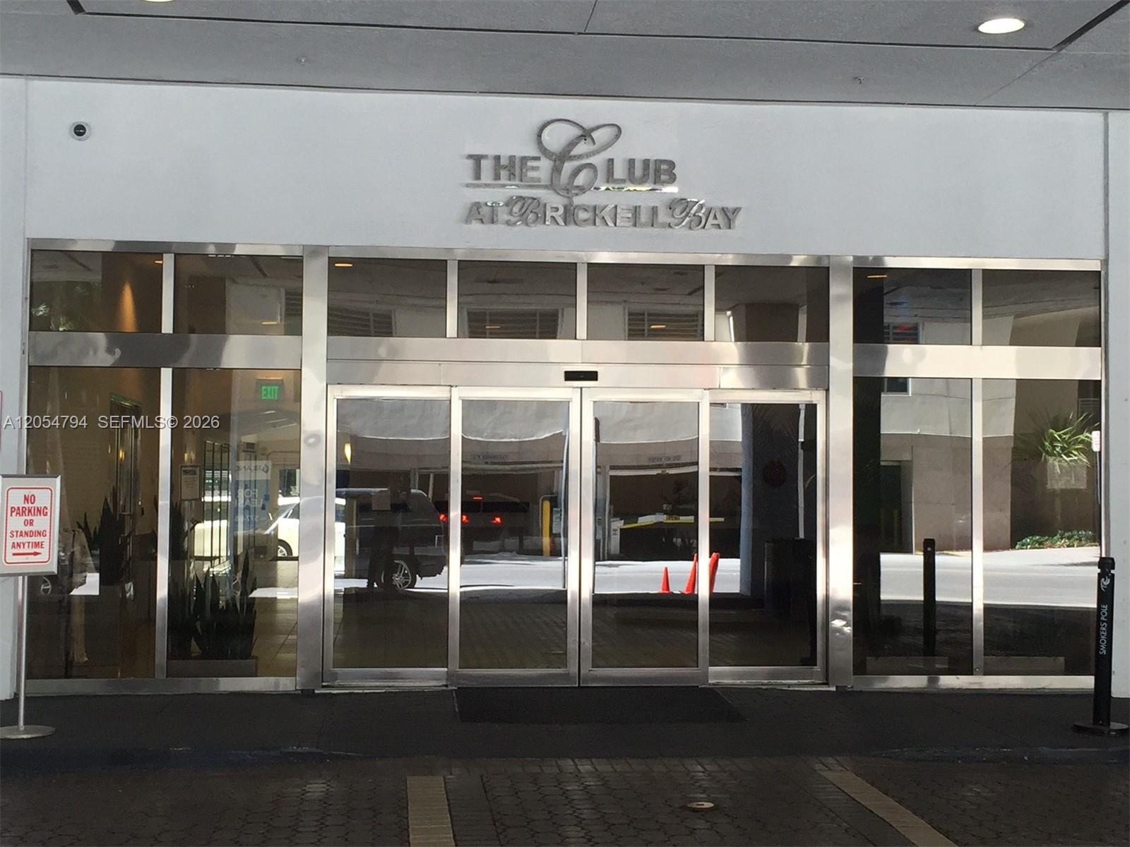 The exterior entrance of a building features glass doors and a metal sign above — 1200 S Brickell Bay Dr # 3317, Miami FL 33131, MIAMI, FL