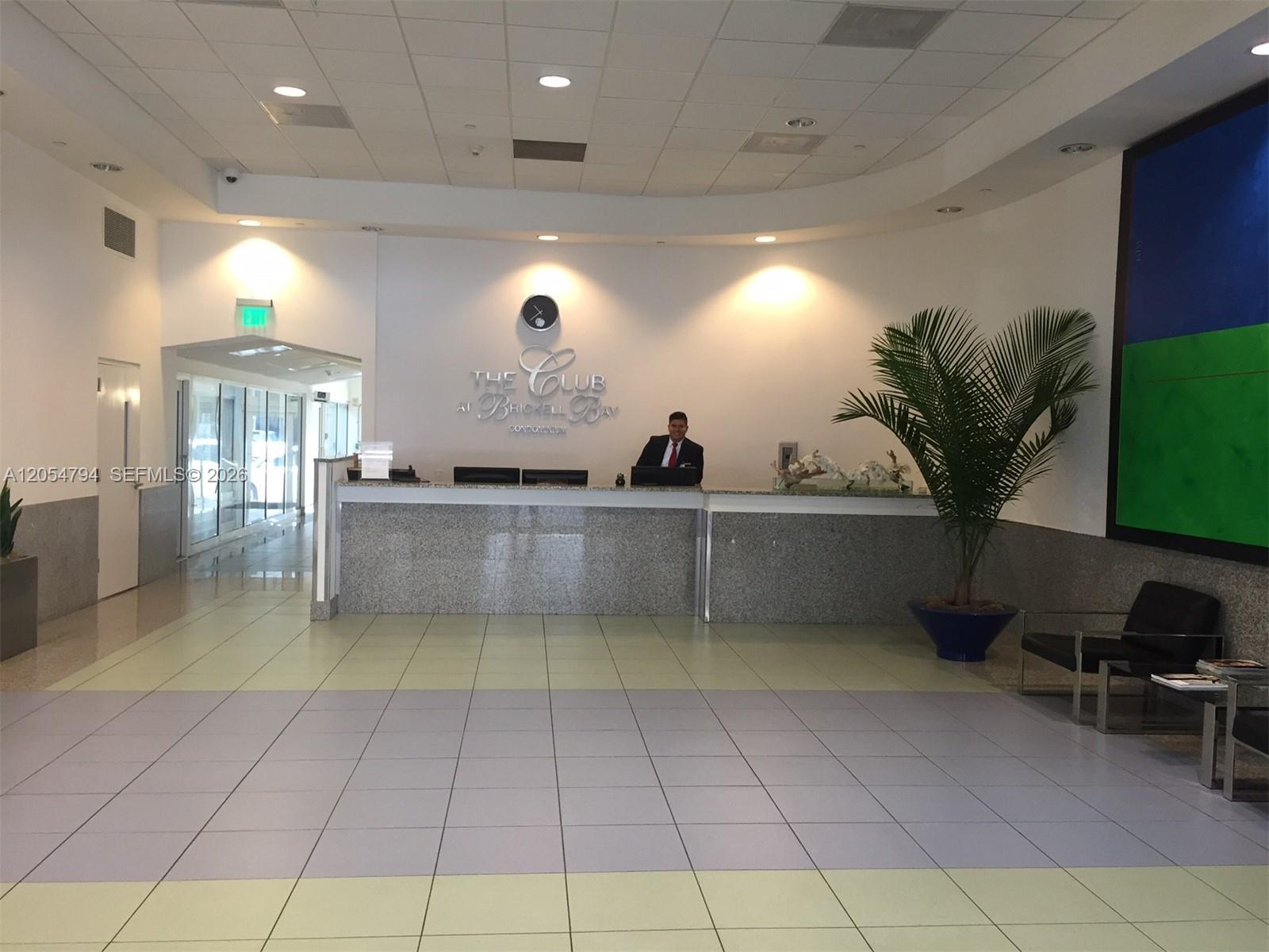 A concierge desk sits in the lobby of a condominium building with tiled floors — 1200 S Brickell Bay Dr # 3317, Miami FL 33131, MIAMI, FL
