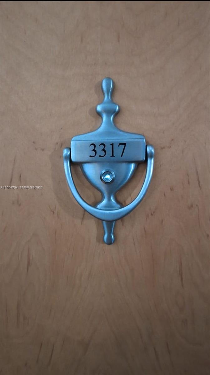 A silver door knocker with the number 3317 is mounted on a light wood door — 1200 S Brickell Bay Dr # 3317, Miami FL 33131, MIAMI, FL