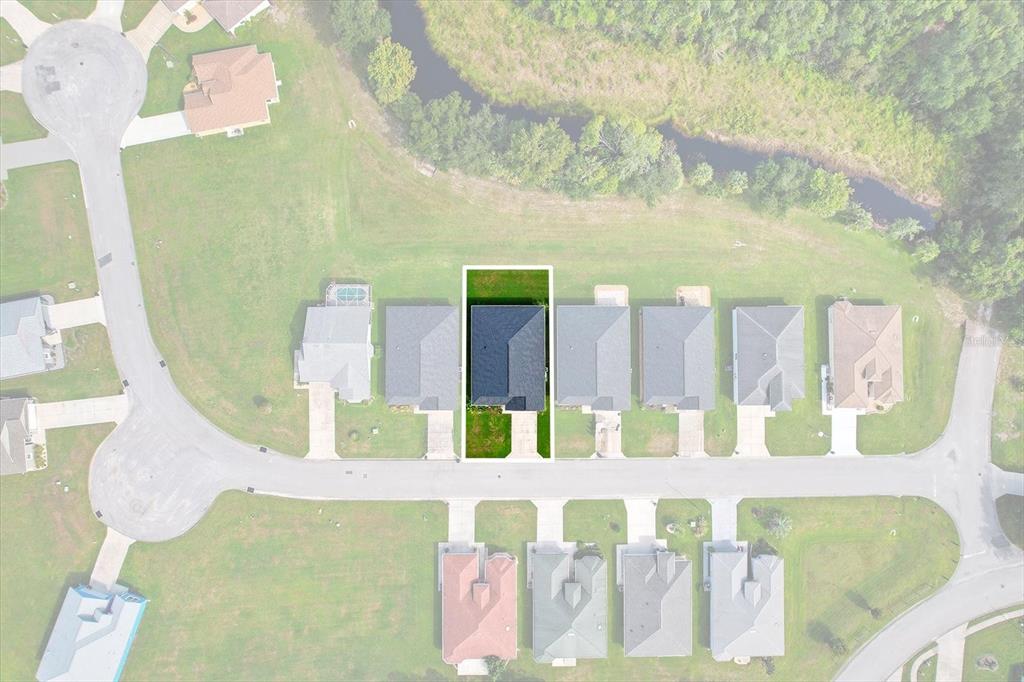 An aerial view shows a residential neighborhood with a highlighted house and its surrounding lots — 9689 E WHITE EGRET PATH, INVERNESS, FL