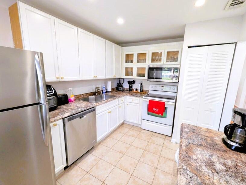 A kitchen features white cabinets, stainless steel appliances, and brown laminate countertops — 21362 Juego Circle # 33f, Boca Raton FL 33433, BOCA RATON, FL