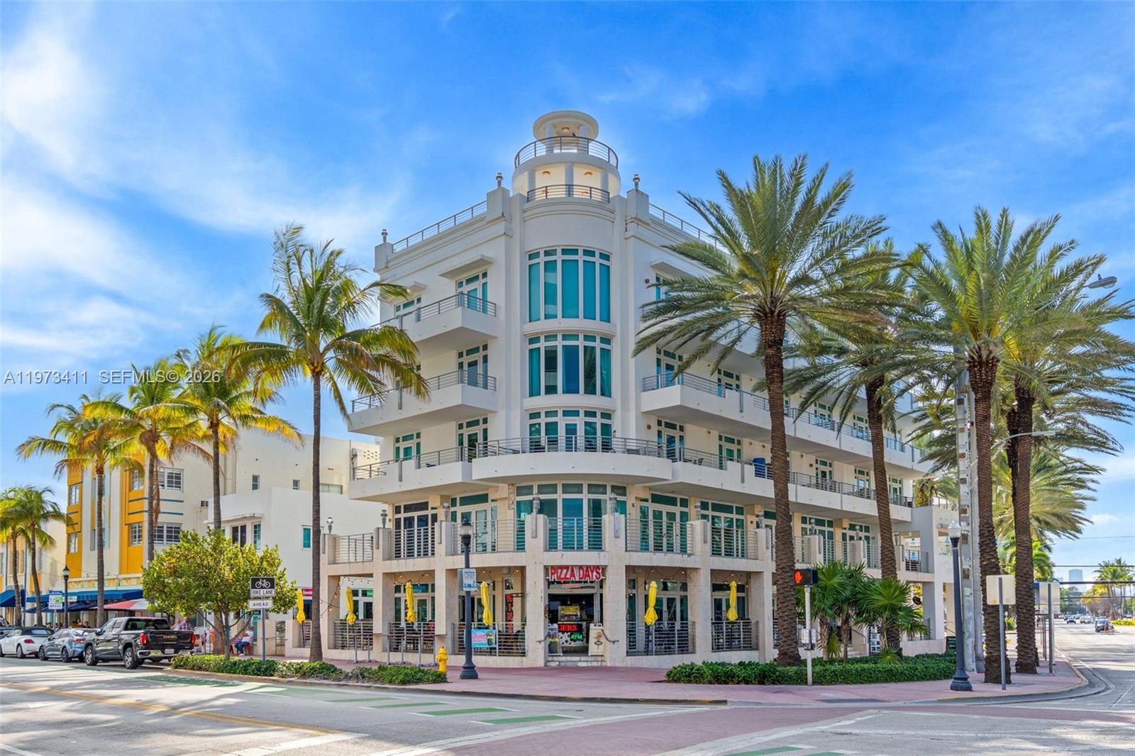 A multi-story white building with a rounded corner, balconies, and a ground-floor pizza restaurant — 448 Ocean Dr # 303, Miami Beach FL 33139, MIAMI BEACH, FL