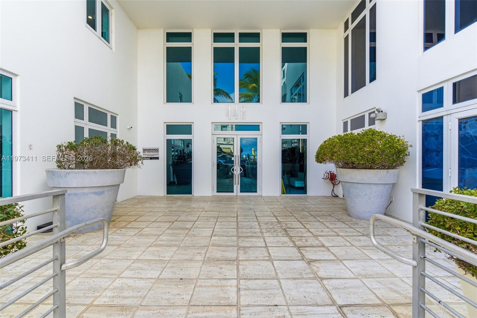 The exterior entrance features a tiled patio, large potted plants, and glass double doors — 448 Ocean Dr # 303, Miami Beach FL 33139, MIAMI BEACH, FL
