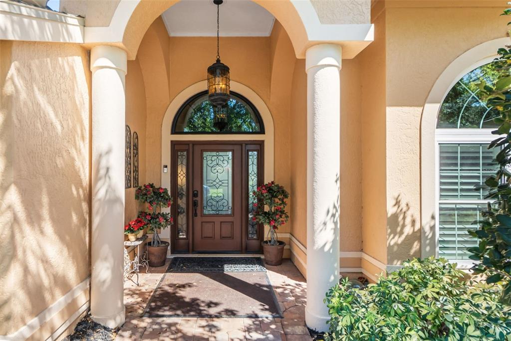 A single-story house with a tan exterior, a brown garage door, and a large tree — 8309 SHADOW PINE WAY, SARASOTA, FL