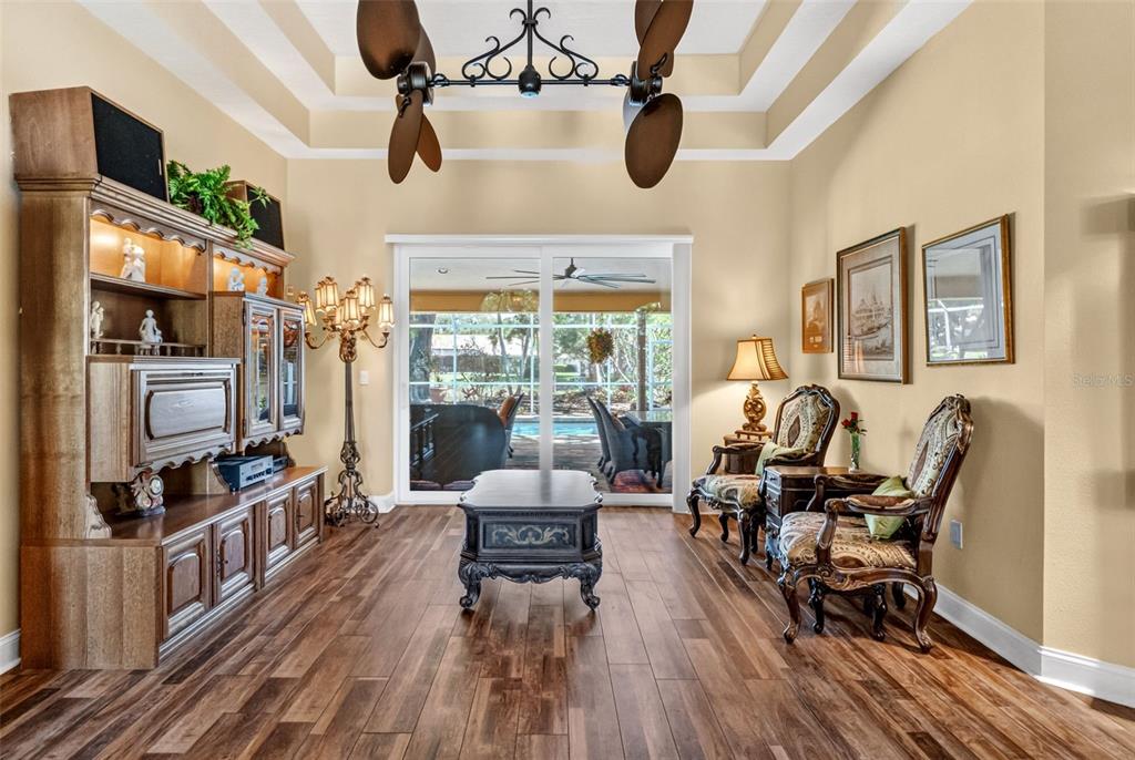A front entryway features a wooden door with glass panels, two white columns, and potted plants — 8309 SHADOW PINE WAY, SARASOTA, FL