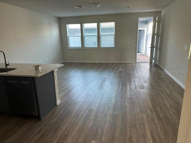 An open-concept living area features light wood-look flooring, neutral walls, and a kitchen island — 14322 SAPELO BEACH DRIVE, ORLANDO, FL