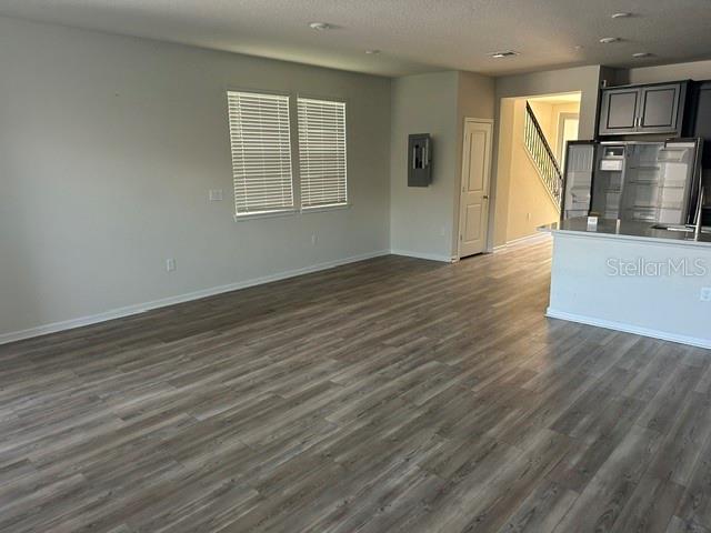 An open-concept living area features light wood-look flooring, neutral walls, and a kitchen island — 14322 SAPELO BEACH DRIVE, ORLANDO, FL