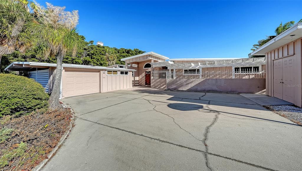 A light-colored house with a large cracked concrete driveway and a detached garage — 355 S SHORE DRIVE, SARASOTA, FL