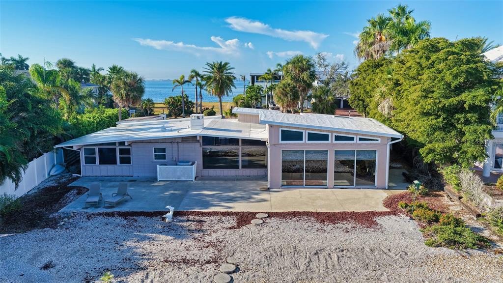 An exterior view of a single-story house with a flat roof and a patio area — 355 S SHORE DRIVE, SARASOTA, FL