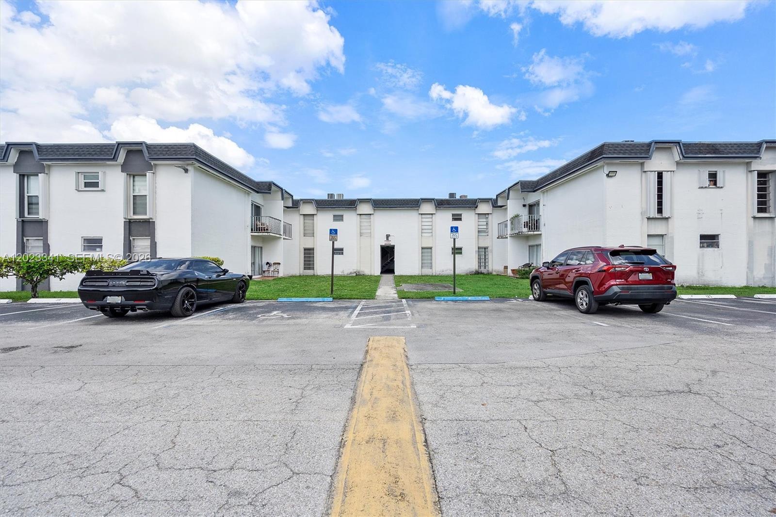 A two-story apartment building exterior with a parking lot in the foreground — 7232 SW 94th Pl # E6, Miami FL 33173, MIAMI, FL