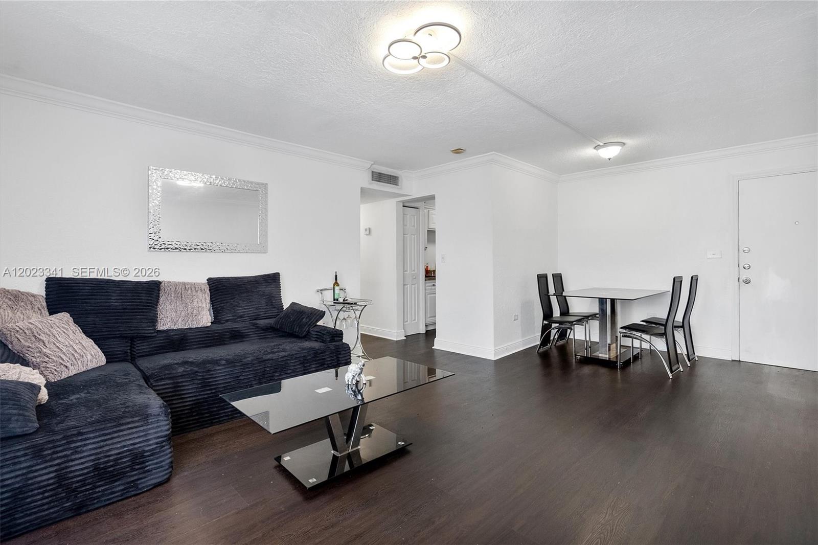 A living and dining room with dark wood floors, white walls, and modern furniture — 7232 SW 94th Pl # E6, Miami FL 33173, MIAMI, FL