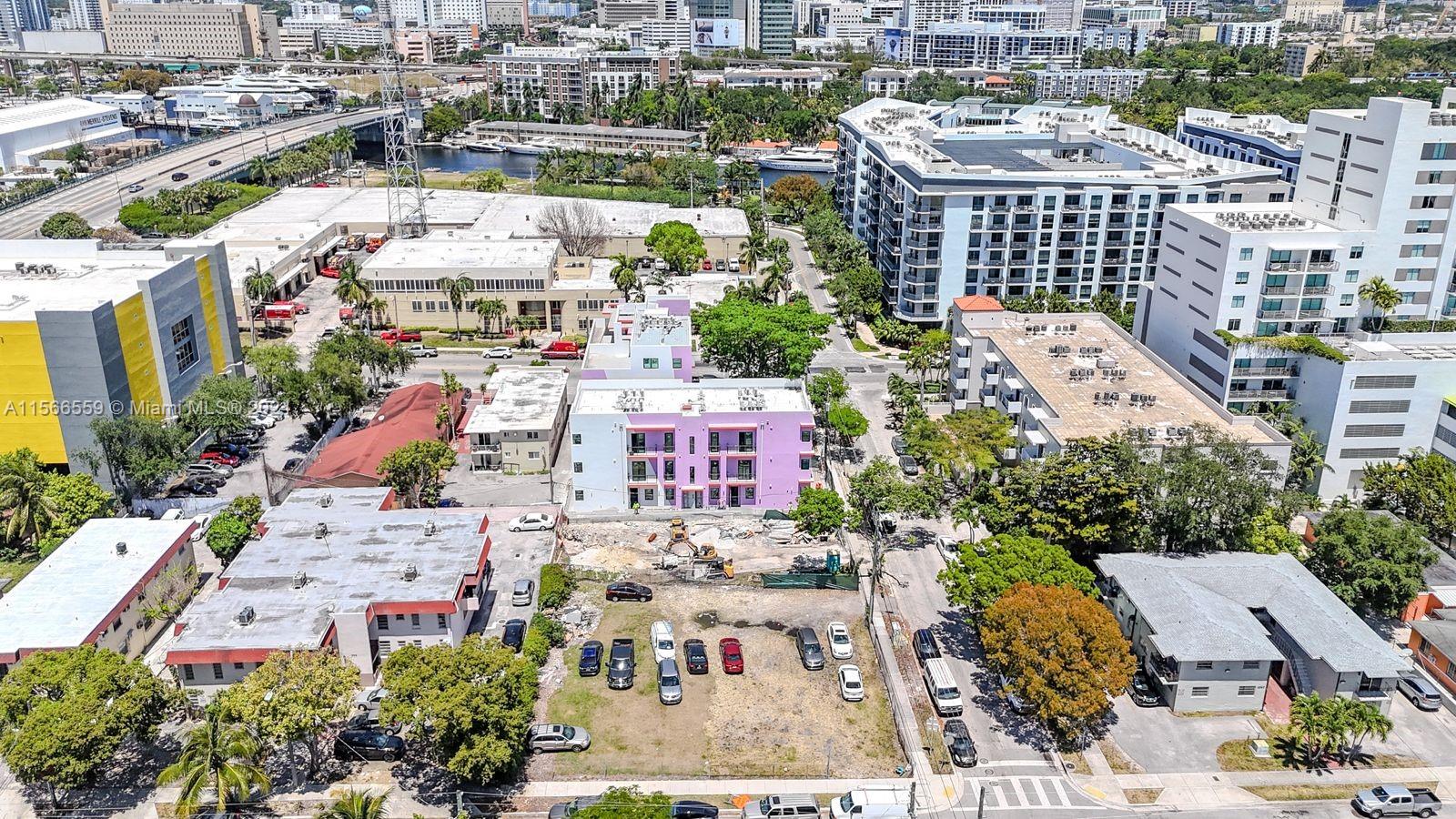An aerial view shows a pink apartment building surrounded by urban development and parking lots — 1111 NW 6th St, Miami FL 33136, MIAMI, FL