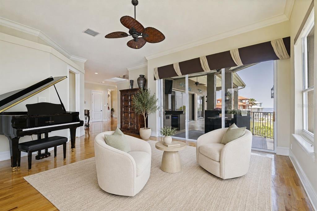 A dining room features a wooden table, upholstered chairs, a chandelier, and a curved staircase — 4631 HARBORPOINTE DRIVE, PORT RICHEY, FL