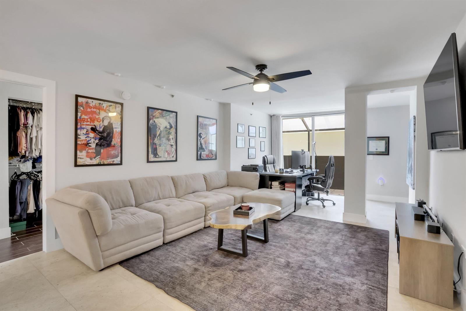 A living room features a large beige sectional sofa, a coffee table, and a home office — 3237 Clint Moore Road # 103, Boca Raton FL 33496, BOCA RATON, FL