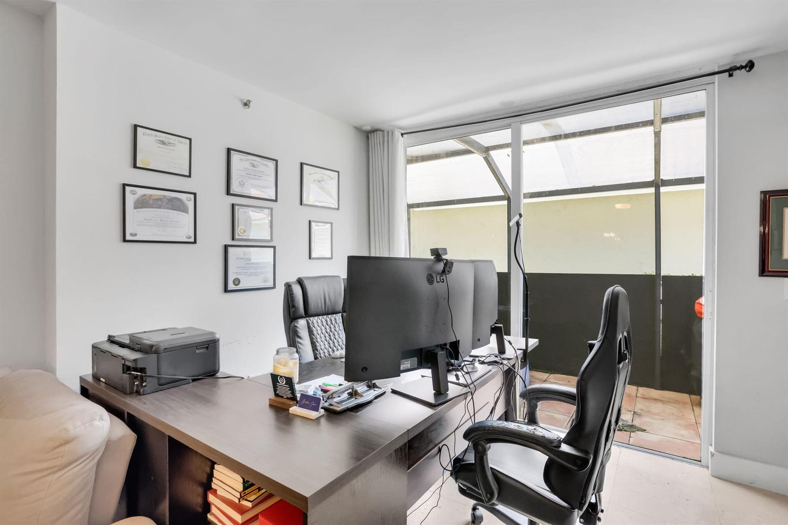 A home office features a dark wood desk, two computer monitors, and framed wall certificates — 3237 Clint Moore Road # 103, Boca Raton FL 33496, BOCA RATON, FL