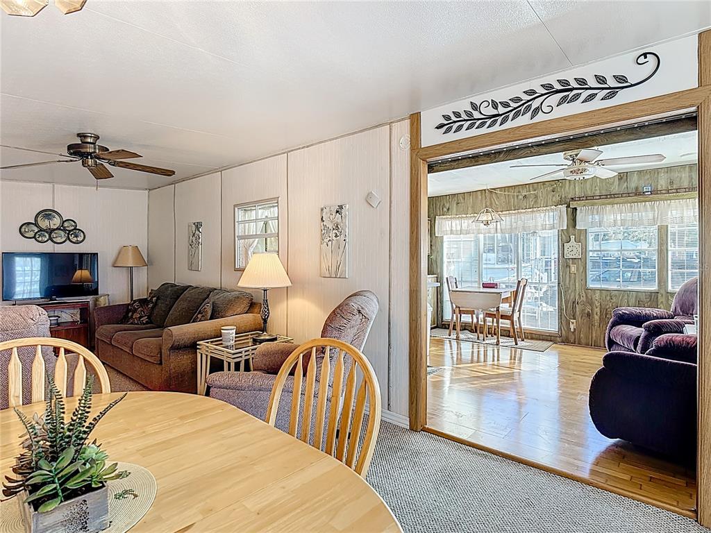 A living room with a dining area visible through a wide doorway — 9000 US HWY 192 UNIT 849, CLERMONT, FL