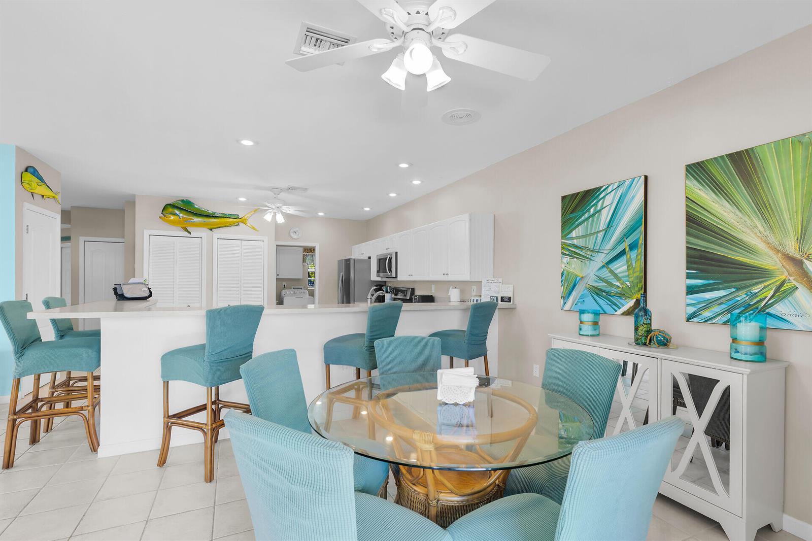 A kitchen with white cabinets and a dining area featuring a glass-topped table and chairs — 180 9th Street, FL 33051, FL