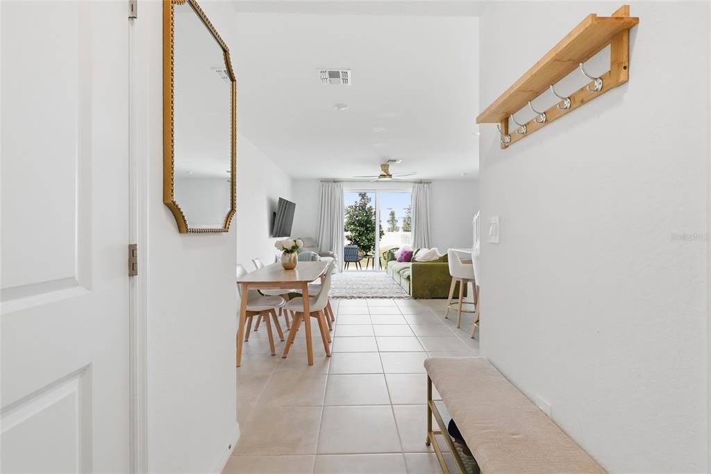 An entryway leads into an open-concept living and dining area with tile flooring and patio access — 14215 LILAC SKY TERRACE, BRADENTON, FL