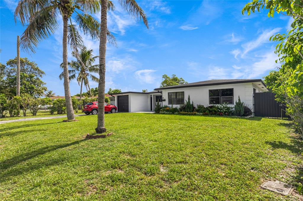 A single-story white house with a dark roof sits behind a large grassy lawn — 24 NW 42ND TERRACE, PLANTATION, FL