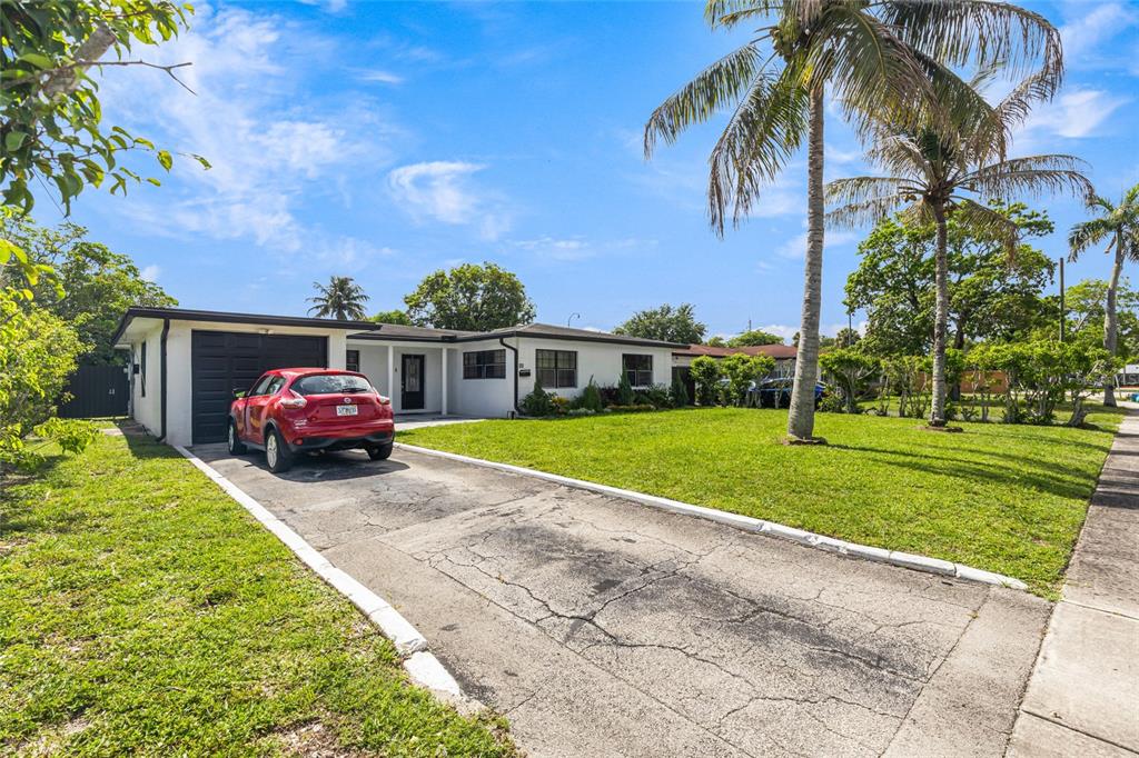 A single-story house with a white exterior, a black garage door, and a red car — 24 NW 42ND TERRACE, PLANTATION, FL