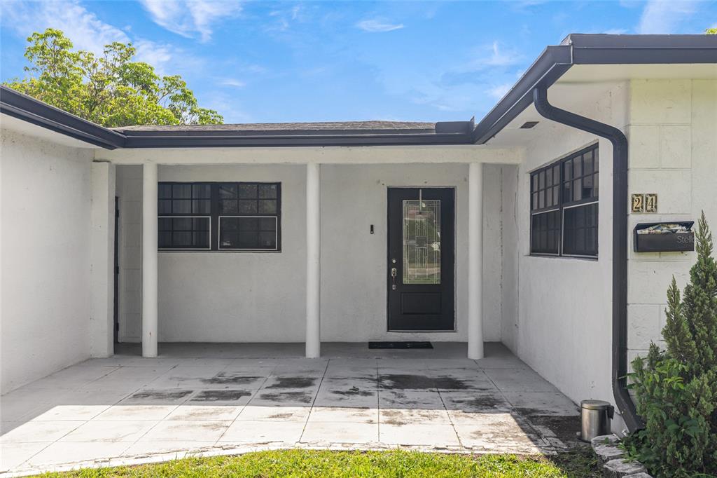 A white house exterior features a covered patio, a black front door, and a mailbox — 24 NW 42ND TERRACE, PLANTATION, FL