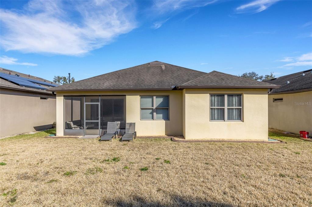 A screened-in patio features a ceiling fan, outdoor furniture, and views of a grassy yard — 329 ALICANTE COURT, DAVENPORT, FL