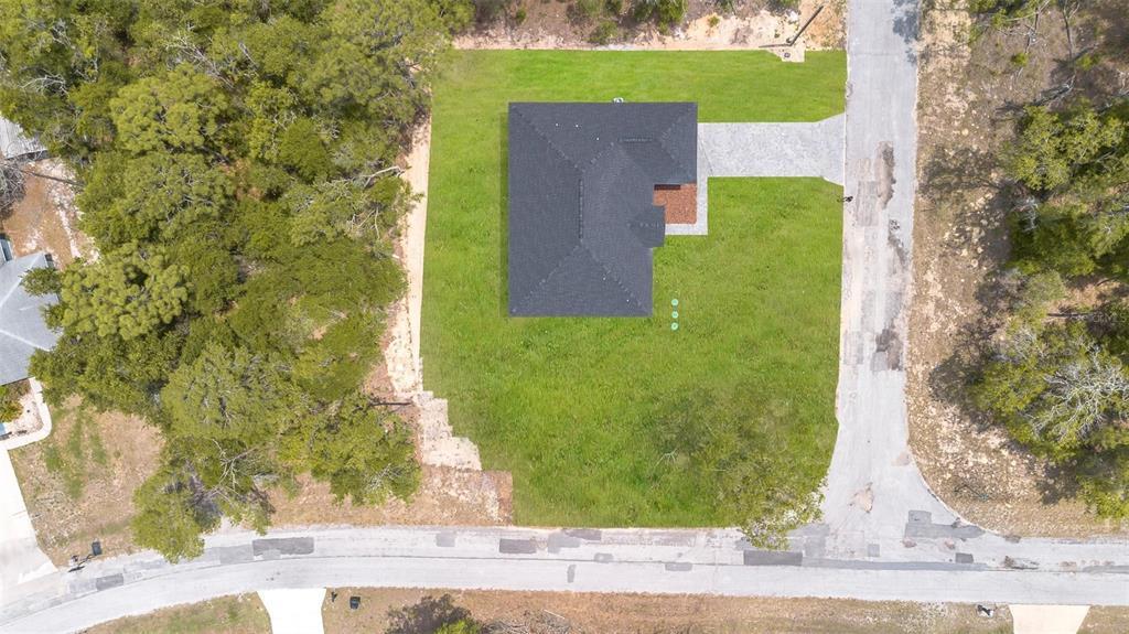 An aerial view shows a house with a dark roof centered on a grassy lot — 9651 W PINEVIEW WAY, DUNNELLON, FL