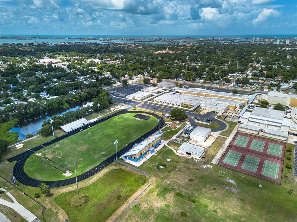 An aerial view of a school campus featuring a track, football field, and tennis courts — 1714 55TH STREET S, GULFPORT, FL