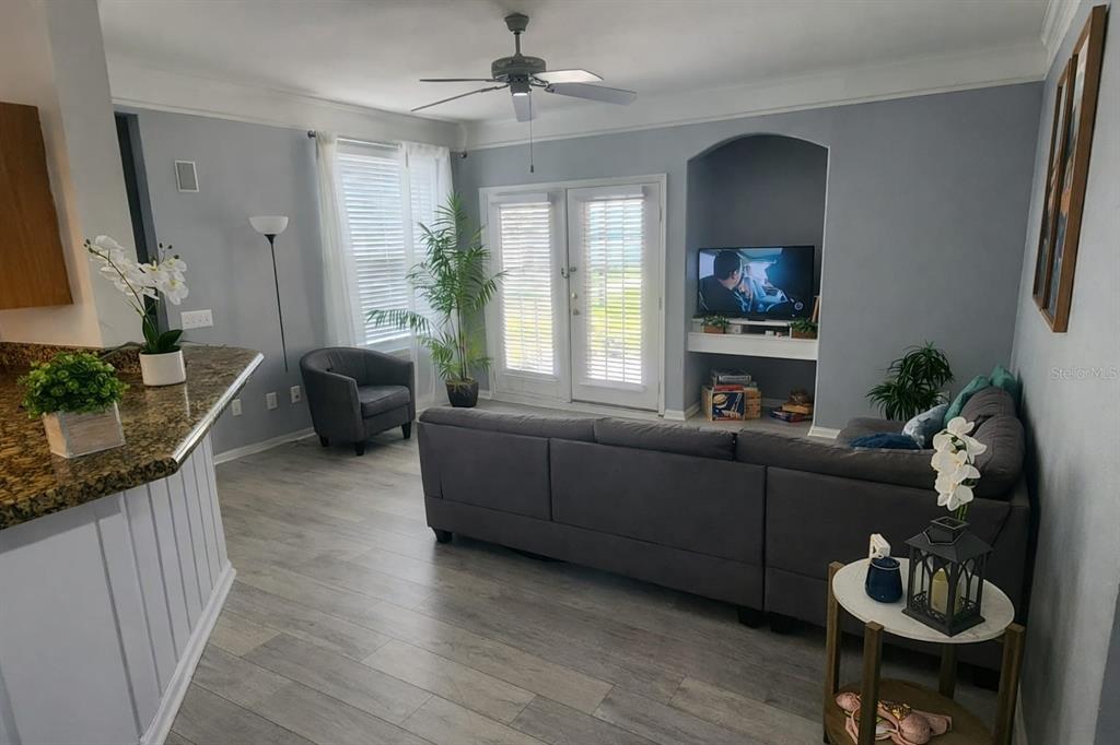 A living room features a grey sectional sofa, a ceiling fan, and a built-in TV niche — 3016 BONFIRE BEACH DRIVE UNIT 104, KISSIMMEE, FL