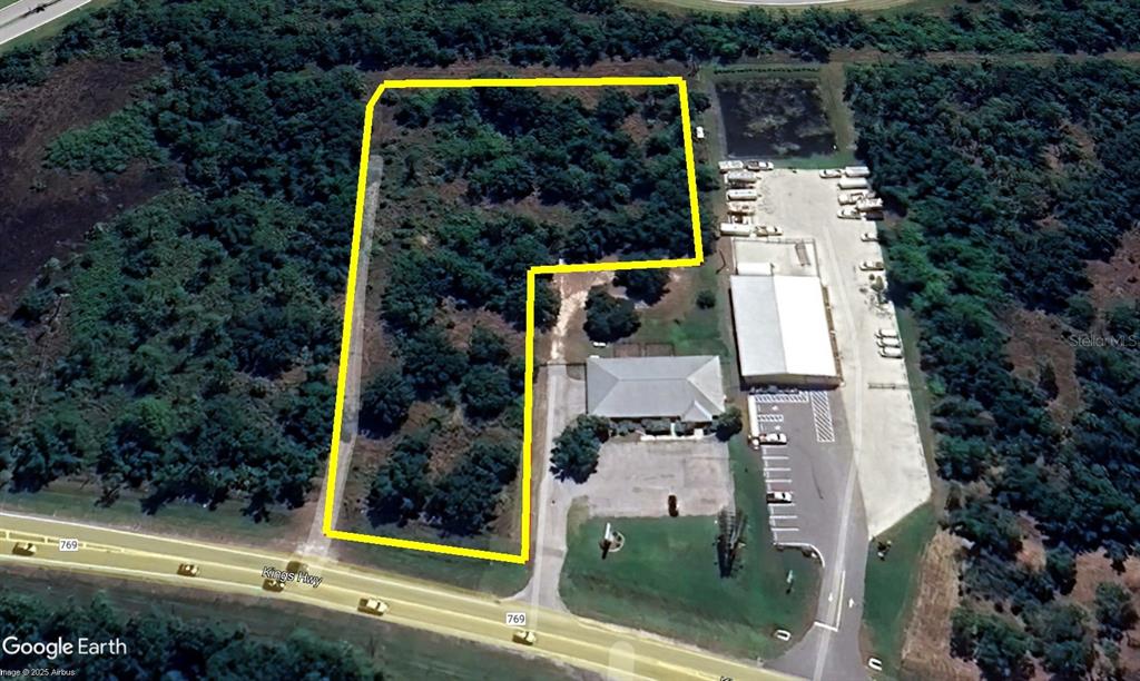 An aerial view shows a vacant, wooded lot outlined in yellow adjacent to a commercial property — 12280 SW COUNTY ROAD 769, LAKE SUZY, FL
