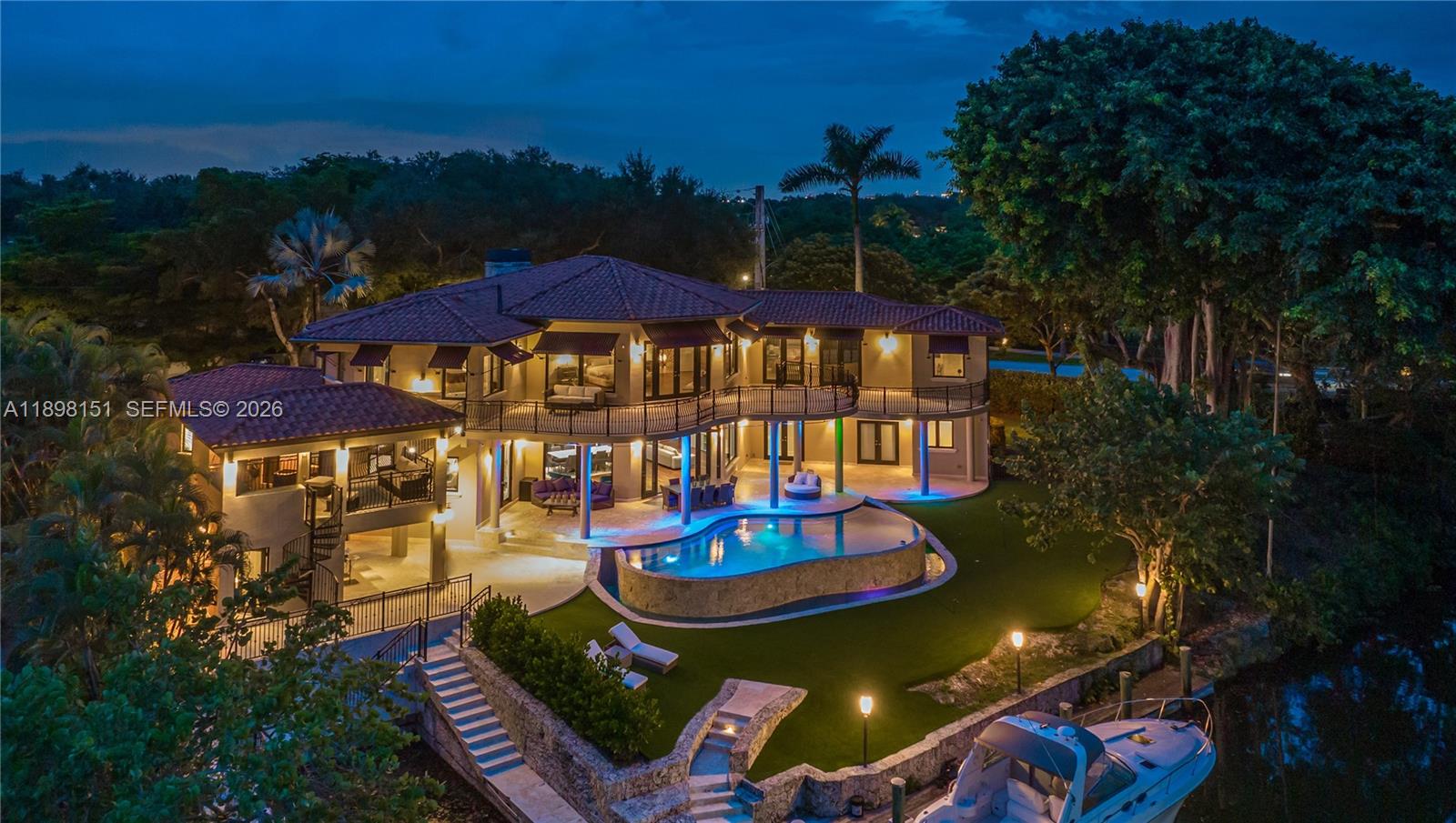An aerial view of a two-story house at night featuring a pool and a boat — 6700 Granada Blvd, Coral Gables FL 33146, CORAL GABLES, FL