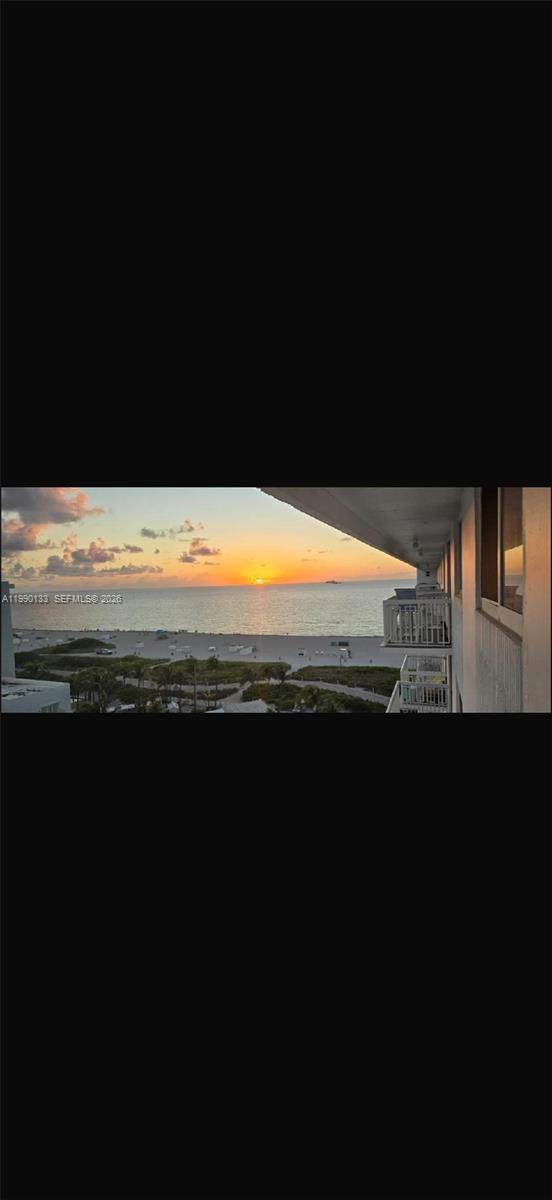 A view from a balcony overlooking a sandy beach and the ocean at sunset — 401 Ocean Dr # 1124, Miami Beach FL 33139, MIAMI BEACH, FL